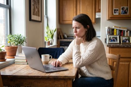 Femme en sweater et jeans travaillant à la maison